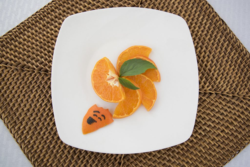 A dismembered orange on a plate