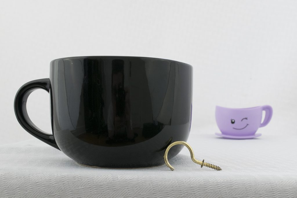 Two coffee cups and a brass hook